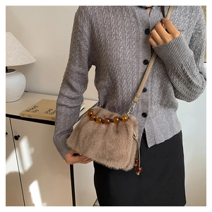 Détail du sac à bandoulière en fausse fourrure avec poignée en perles d'ambre