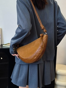Brown leather and suede patchwork half-moon shoulder bag with unique knotted strap detail