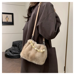 Détail du sac seau en peluche avec poignée en perles élégante et bandoulière en cuir