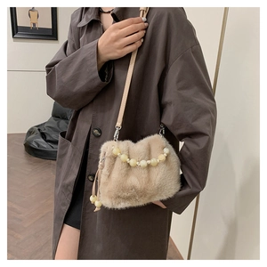 Détail du sac seau en fausse fourrure léopard avec poignée perlée et bandoulière