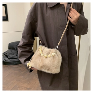 Détail du sac seau en peluche léopard avec poignée en perles et bandoulière amovible