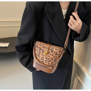 Dettaglio della borsa a secchiello leopardata con chiusura a scatto su cappotto scuro
