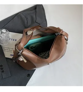 Spacious interior of brown leather tote bag showing pockets for tablet and phone