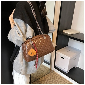 Brown quilted pillow bag with silver chain strap and plush puppy charm detail