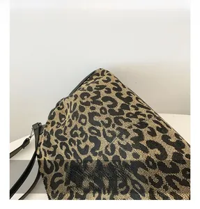 Close-up of leopard print jacquard fabric texture and black leather strap details