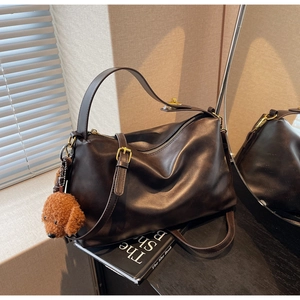 Detail of coffee brown Hobo bag with plush teddy bear charm and gold zipper accents