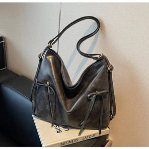 Detail of dark grey vintage PU leather tote with butterfly zip pullers and gold hardware