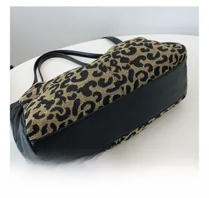 Detailed view of reinforced stitching and leopard print fabric on the tote bag base