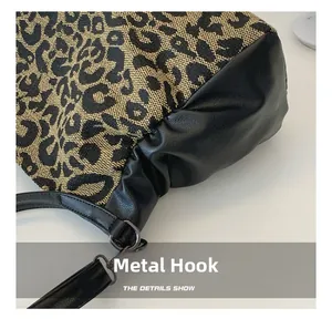 Close-up of leopard jacquard fabric and black leather texture with metal hook detail