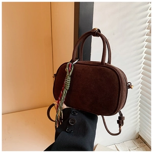 Détail du sac à main en daim marron foncé avec poignées et cordon tressé