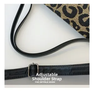 Close-up of leopard print tote featuring adjustable leather strap and metal buckle