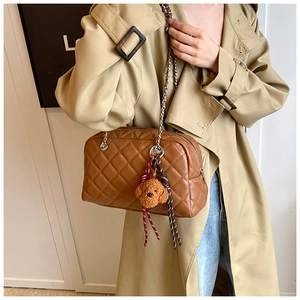 Brown quilted pillow bag with silver chain strap and a cute puppy plush charm detail