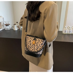 Dettaglio della borsa a secchiello leopardata con finiture in pelle nera a spalla