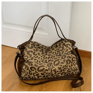 Close-up of leopard jacquard tote bag with dark brown leather trim and silver hardware