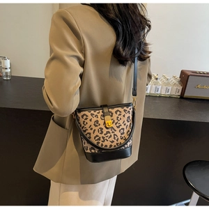 Dettaglio borsa a secchiello leopardata con finiture in pelle nera e chiusura a girello