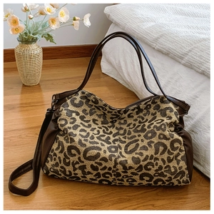 Detailed view of leopard print tote bag with brown leather straps and adjustable strap