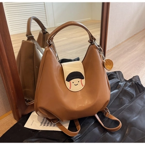 Brown faux leather convertible backpack with cartoon baseball flap and matching charm