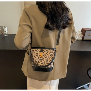 Dettaglio della borsa a secchiello leopardata con chiusura dorata a tracolla per donna