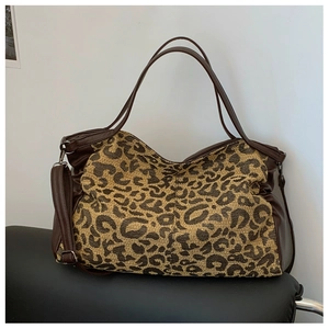 Close-up of leopard print tote bag with woven texture and premium brown leather straps