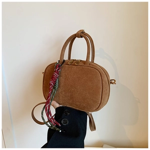 Détail du sac bowling vintage en daim marron avec pendentif en corde tressée