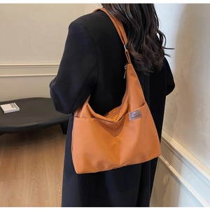 Détail du grand sac cabas en nylon orange-brun avec poches latérales et bandoulière