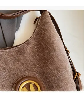 Detail of vintage brown velvet tote bag showing textured fabric and leather straps