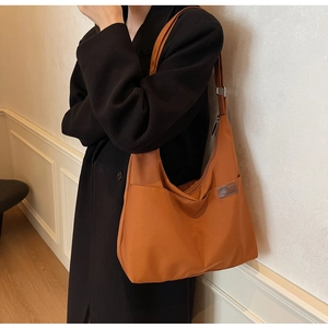 Vue détaillée du sac fourre-tout en toile orange brûlée avec logo en cuir et zip