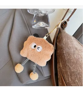 Detail of cute brown plush pendant with striped long legs hanging on a velvet bag