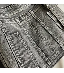 Detail of grey washed denim fabric showing reinforced stitching and metal buckle