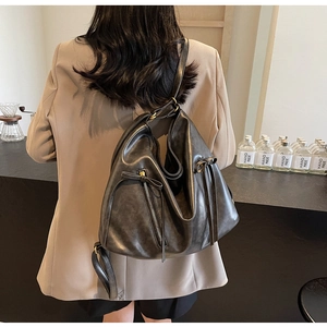 Close-up of vintage soft leather bag with bow detail and bronze metal zipper