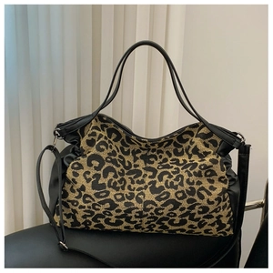 Detail view of leopard print tote bag with black synthetic leather strap and handles