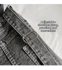 Detail of adjustable denim strap with matte metal buckle on a black wash tote bag
