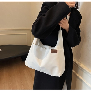 Détail du grand sac cabas blanc en toile avec patch en cuir et fermeture éclair