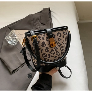 Dettaglio borsa a secchiello leopardata con chiusura a rotazione dorata e pelle nera