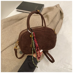 Détail du sac à main en daim marron foncé avec clé vintage en métal et accessoire tressé