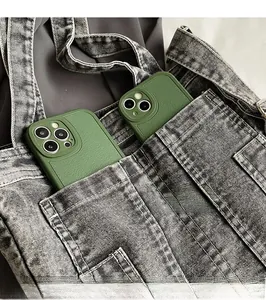 Detail showing dark green litchi leather phone cases stored in denim pocket