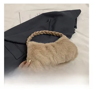 Gros plan du sac à main en fausse fourrure kaki avec poignée en cuir tressé sur un blazer chic
