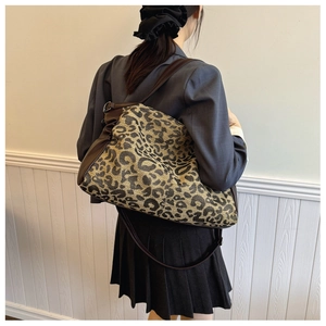 Detailed shoulder view of leopard print tote bag with brown leather strap detail
