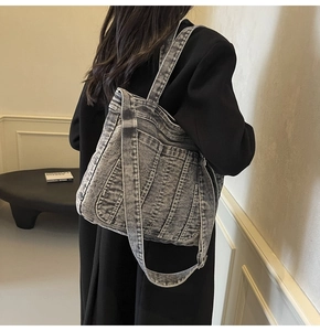Detail of vintage denim tote bag featuring vertical pleated texture and dual straps