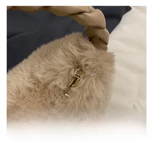 Gros plan du fermoir doré et de la poignée tressée sur le sac à bandoulière en peluche