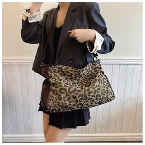 Close-up of leopard print tote bag fabric with soft texture and leather strap detail