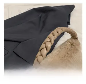 Gros plan sur un sac en fausse fourrure beige avec une anse tressée en cuir élégante