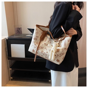 Detail of artistic graffiti tote bag with plush rabbit charm for daily office commute