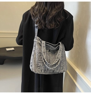 Detail of grey-blue washed denim tote bag showing wide shoulder strap and side view