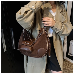 Detail einer dunkelbraunen Wildleder-Hobo-Tasche mit abnehmbarem Mini-Portemonnaie und Kette