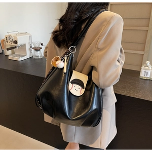 Detail of black matte PU backpack with baseball themed embroidery and cute 3D charms