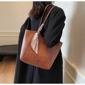 Detail der karamellbraunen Leder-Shopper mit kariertem Seidenschal-Dekor am Griff