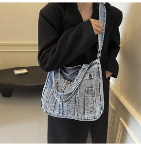 Detail of blue denim tote bag with functional pockets and adjustable crossbody strap