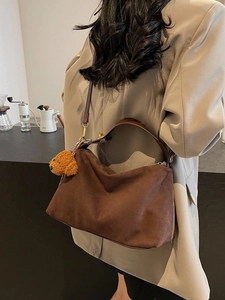 Retro brown suede hobo tote bag with bear charm shown on model in autumn setting