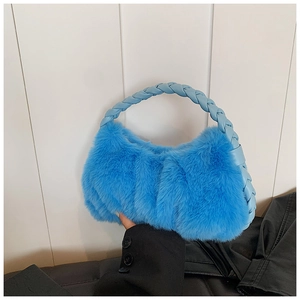 Détail du sac à main en peluche bleu vif avec fausse fourrure douce et poignée tressée